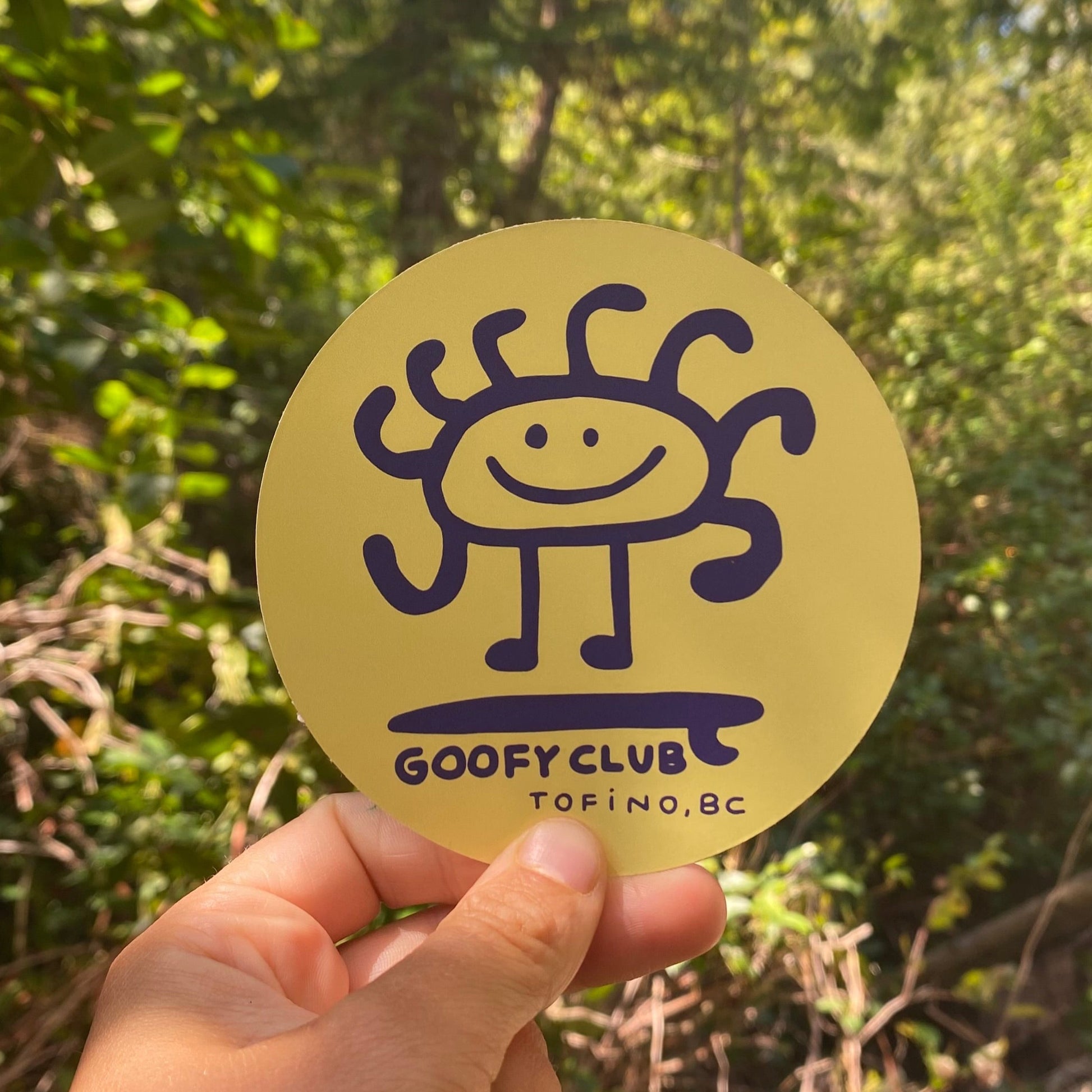 A circular yellow sticker with a smiling sun character and "Goofy Club Tofino, BC